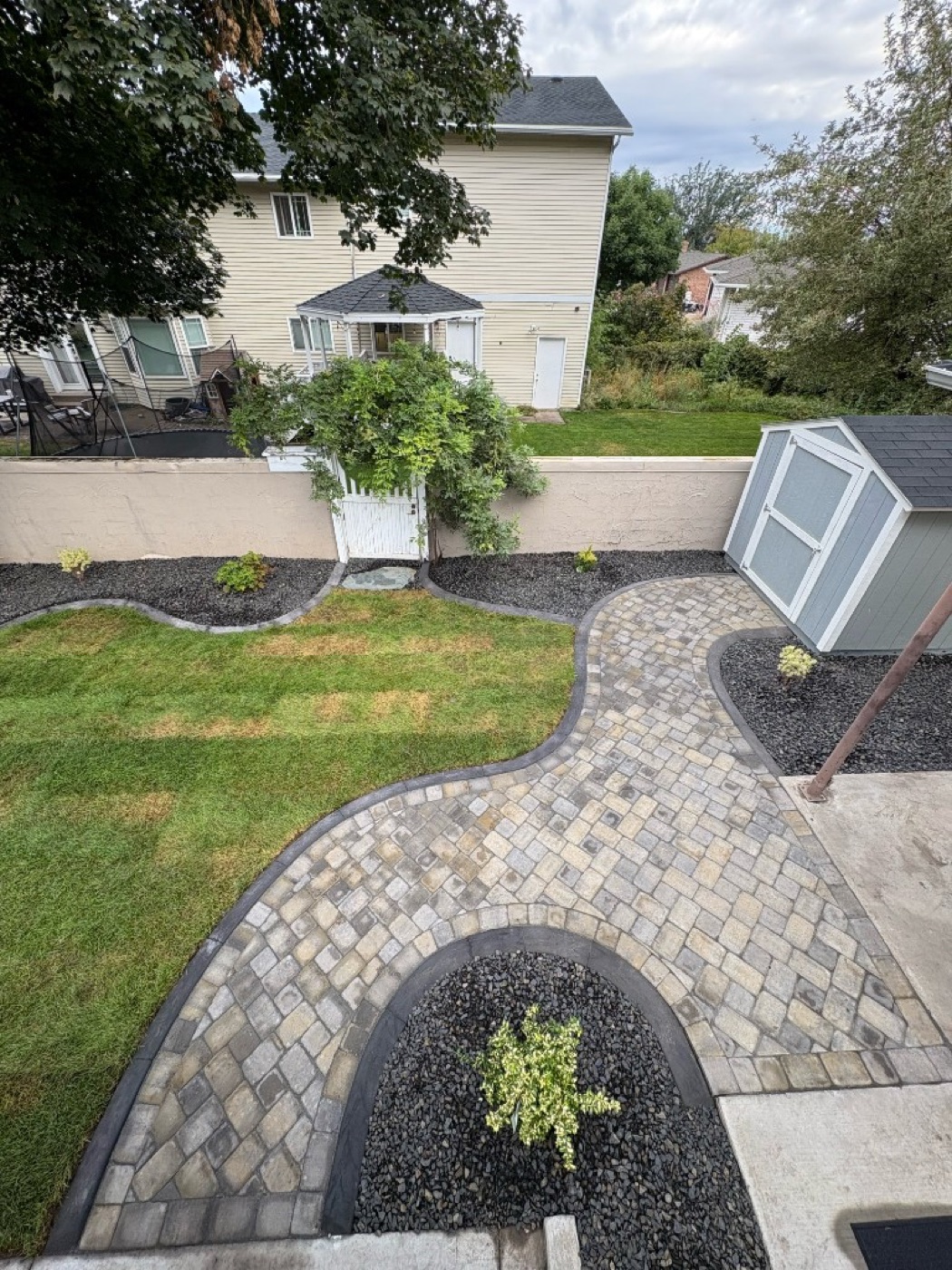Aerial view of a Utah backyard with cobblestone paver patio and concrete curbing